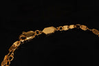 Close-up detail of FFIENLEE 925 sterling silver Y-lariat necklace in 24K gold tone, showing the lobster claw clasp, branded tag, and flat tile chain links on black background