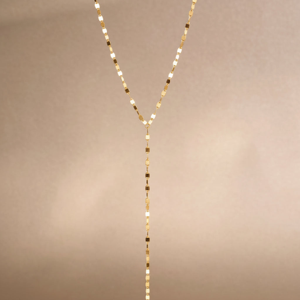 FFIENLEE 925 sterling silver Y-lariat tile chain necklace in 24K gold tone, full-length product shot on warm beige background, showing the V-shaped chain and elongated drop