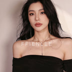 Close-up of model's neck and collarbone wearing FFIENLEE 925 sterling silver Y-lariat tile chain necklace with double bar pendant in 24K gold tone, paired with long tassel earrings, styled with a black strapless top, warm beige background